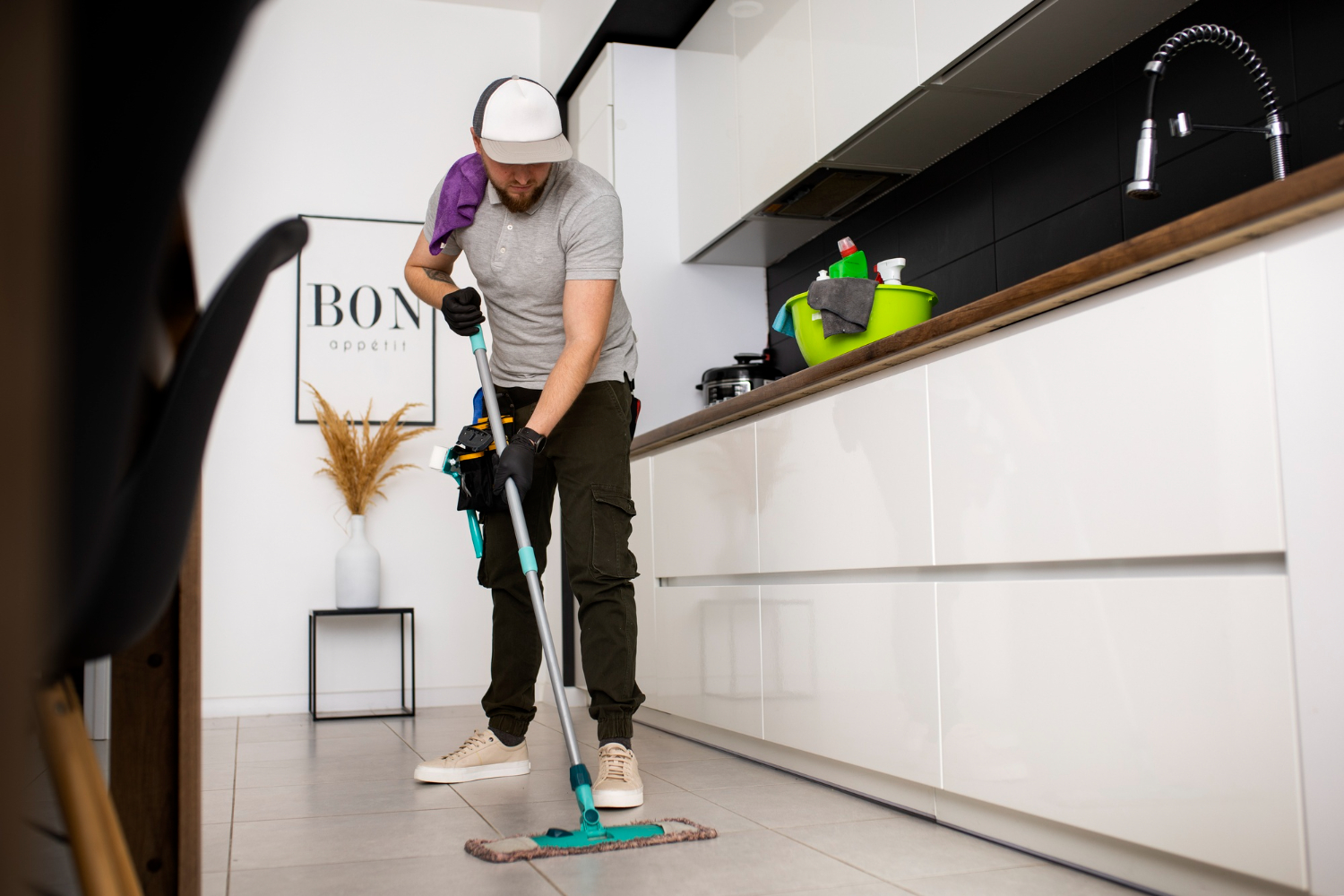 Professional cleaner mopping kitchen floor during commercial cleaning service